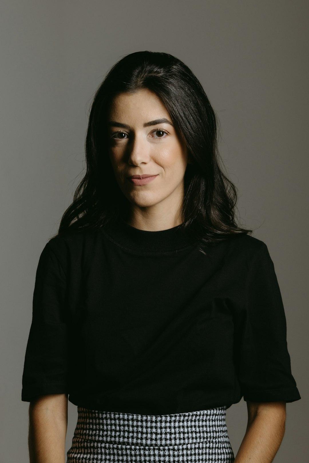 a woman in a black shirt and checkered skirt