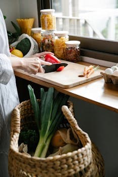 A person slices vegetables on a kitchen countertop, showcasing fresh produce and culinary preparation.