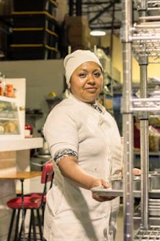 Portrait of a female chef in a white uniform working in a busy kitchen in Mexico City.