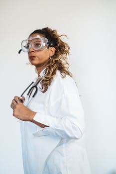 Female doctor wearing safety goggles and stethoscope, portraying professionalism.