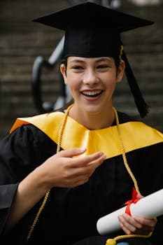 A happy graduate in cap and gown celebrates success with a diploma in hand, symbolizing achievement.