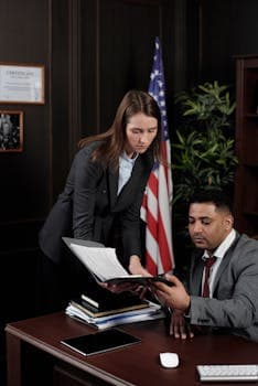 Business professionals discussing documents in a US-themed office setting.