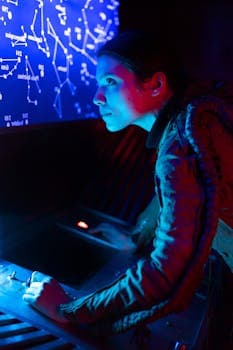 A woman in futuristic attire operates a space control panel under blue light, exploring interstellar possibilities.
