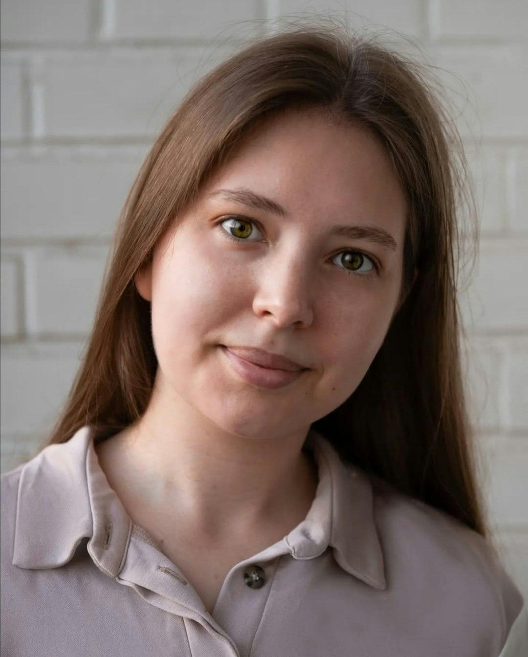 A young woman poses with a subtle smile.
