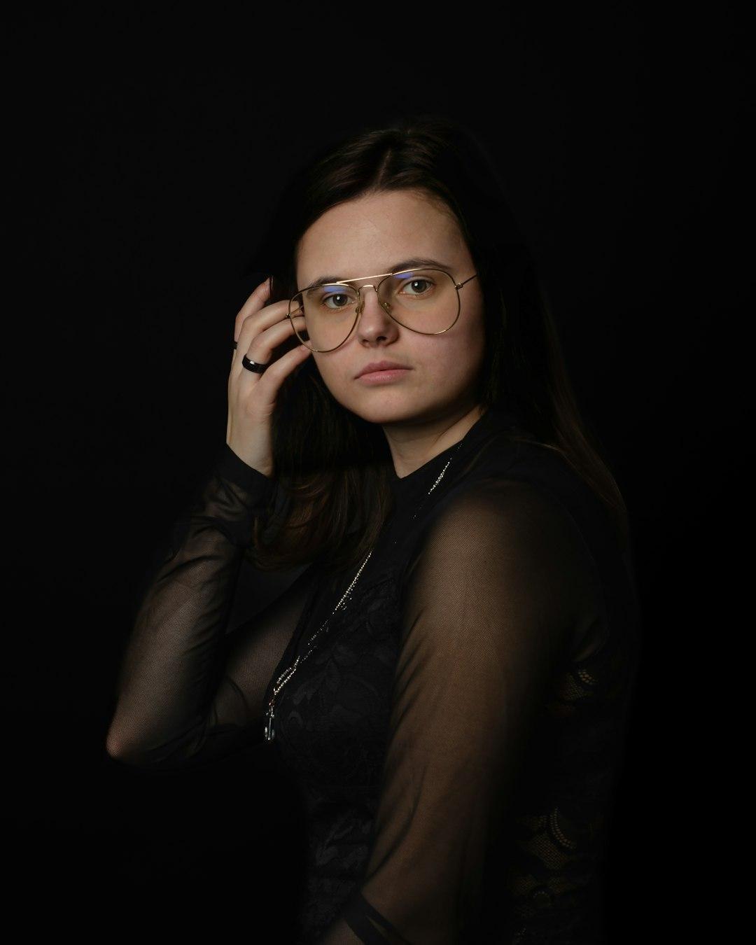 a woman wearing glasses is posing for a picture