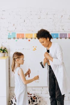 A teacher and student conduct a chemistry experiment in a bright, indoor classroom setting.