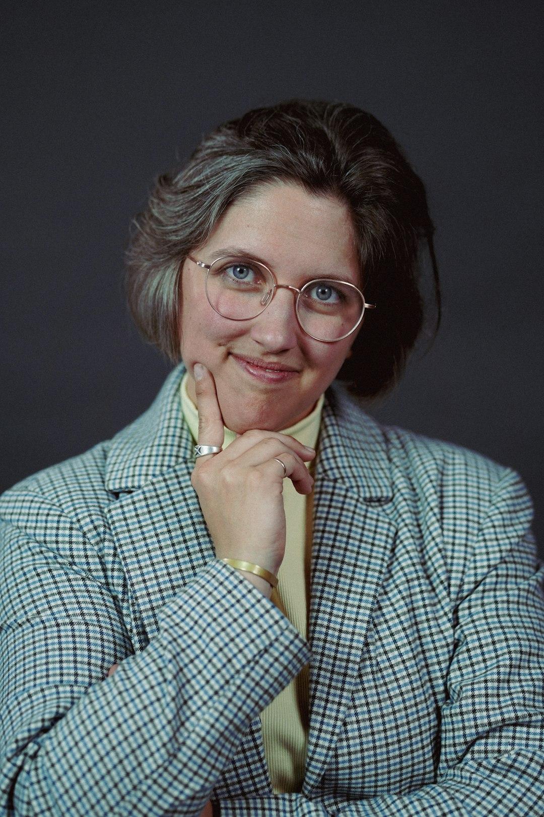 a woman in a suit and glasses posing for a picture